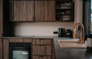 a kitchen with wooden cabinets and a sink at Duża Holenderka - Lewy Brzeg Narwi in Burlaki