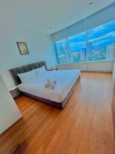una camera da letto con un grande letto bianco con una grande finestra di vortex klcc RR a Kuala Lumpur
