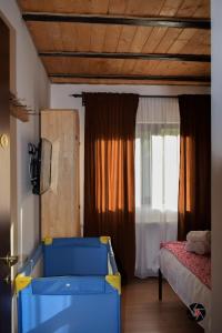 een slaapkamer met een bed en een raam met gordijnen bij Cabana Vasc in Borsa