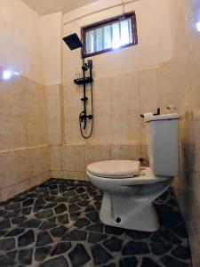 a bathroom with a toilet and a shower at JOSEPH GUEST HOUSE in Kelimutu