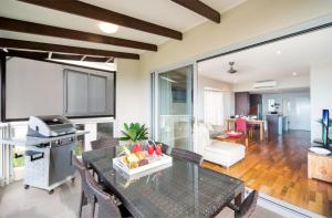 a living room with a glass table and chairs at Oscar's View - Airlie Beach in Airlie Beach