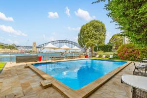 a swimming pool with a bridge in the background at Harbour View with Opera House Overlook in Sydney