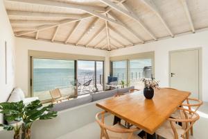 a dining room with a table and a couch at Melivia Seafront Resort in Nea Skioni