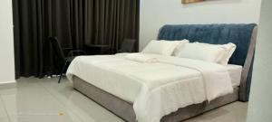 un letto con lenzuola e cuscini bianchi in una stanza di RJ Studio Apartment 1 - Hotel Mutiara a Gua Musang