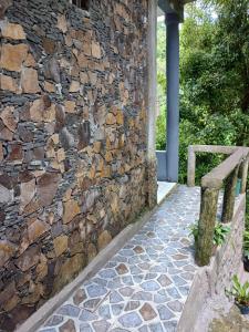a stone wall with a bench next to a building at JOSEPH GUEST HOUSE in Kelimutu