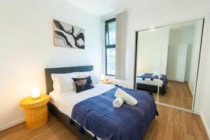 - une chambre avec un grand lit et une couverture bleue dans l'établissement Balmoral Apartment - Airy & Light-filled City Edge Comfort Stay, à Brisbane