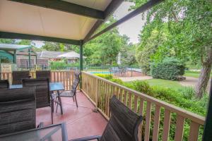 ブライトにあるSilver Birches Holiday Village - Unit 5の椅子とテーブルと柵付きのポーチ