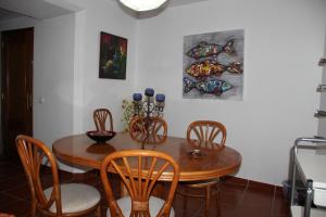 a dining room with a wooden table and chairs at Andar com jardim e estacionamento in Paço de Arcos