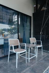 2 chaises et une table en bois avec une table et des chaises dans l'établissement Katig Beachfront Boutique Hotel, à General Luna