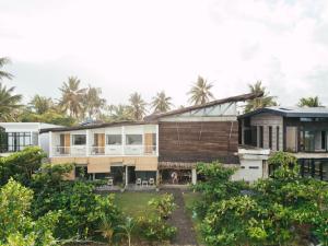 une image d'une maison avec des palmiers en arrière-plan dans l'établissement Katig Beachfront Boutique Hotel, à General Luna