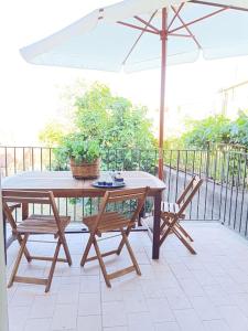 een tafel en twee stoelen en een parasol op een patio bij Casa Etna in Solicchiata