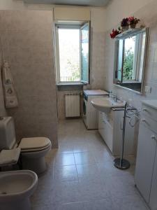 a bathroom with two sinks and a toilet and a window at Casa Etna in Solicchiata