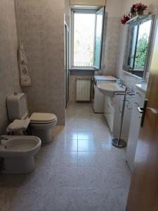 a bathroom with a toilet and a sink and a toilet istg at Casa Etna in Solicchiata