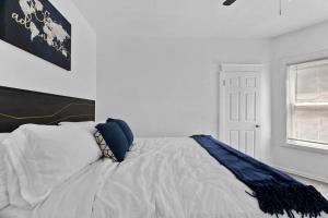 a bedroom with a bed with white sheets and blue pillows at Modern Hyde Park HydeOut (FL1) in Kansas City