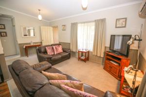 a living room with a couch and a television at Silver Birches Holiday Village - Unit 6 in Bright