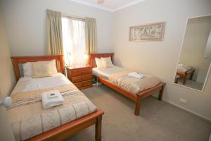 una camera da letto con due letti e uno specchio di Silver Birches Holiday Village - Unit 6 a Bright