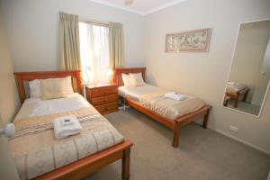 a bedroom with two beds and a mirror at Silver Birches Holiday Village - Unit 6 in Bright