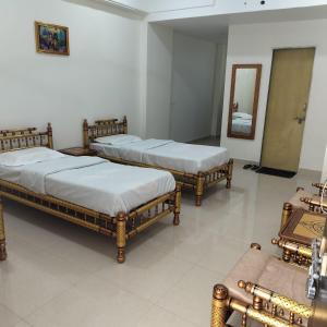 Un grupo de 4 camas en una habitación con espejo en iskcon's GITANAGARI RETREAT CENTER, en Jait