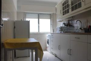 uma cozinha com um frigorífico e uma mesa em GG Massama em Fontainhas