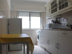 uma cozinha com um frigorífico e uma mesa em GG Massama em Fontainhas