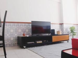 uma televisão de ecrã plano em cima de um centro de entretenimento em GG Massama em Fontainhas