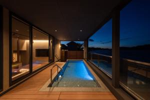 een zwembad op het terras van een huis bij Villa JacoO-ヴィラじゃこまる- in Sanuki