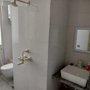 biała łazienka z toaletą i umywalką w obiekcie iskcon's GITANAGARI RETREAT CENTER w mieście Jait