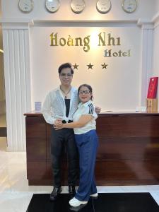 波來古的住宿－Khách Sạn Hoàng Nhi，站在旅馆前面的男人和女人