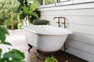 una vasca da bagno bianca seduta su un patio di The Honey Barn, Wabi-Sabi Cottage Byron Hinterland a Clunes