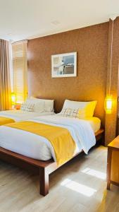 a bedroom with two beds with yellow and white sheets at Canal Village Pakpra Phatthalung in Phatthalung