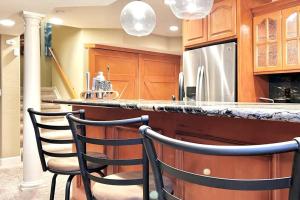 a kitchen with a counter with two chairs at a bar at Large 5BR Retreat - Hot Tub - Gym - Games - I-25 in Castle Rock