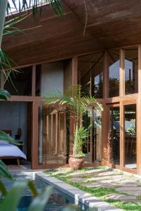 a house with a palm tree in front of it at Masa Kini 3 BR Family Villa with Pool walking distance to Uluwatu Beach in Uluwatu