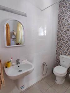 Baño blanco con lavabo y aseo en Ghar el melh, en Ghār al Milḩ