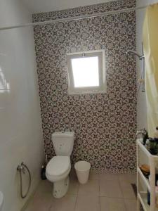 bagno con servizi igienici e finestra. di Ghar el melh a Ghār al Milḩ