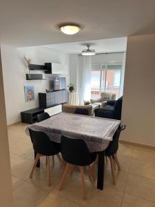 comedor y sala de estar con mesa y sillas en Apartamentos L'Ainsa en Aínsa