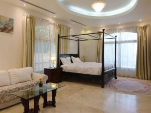 a bedroom with a canopy bed and a couch at Villa Room #3 in Umm Al Sheif in Dubai