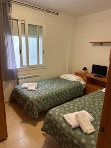 a hotel room with two beds and a window at Apartamentos L'Ainsa in Aínsa