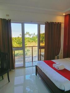 プエルト・プリンセサにあるRoyale Parc Hotel Puerto Princesa Palawanのベッドルーム1室(ベッド1台、大きな窓付)