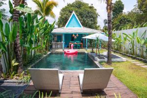 einen Pool mit zwei Stühlen und ein Haus in der Unterkunft Ubu Villa Prambanan - 3 Bedrooms Villa near Prambanan Temple in Prambanan