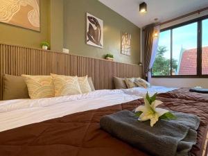 1 dormitorio con 2 camas con una flor encima en Private house with Pagoda view, near Grand Palace, en Bangkok