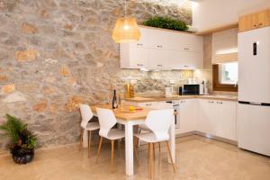 Sweet memories in amazing Villa Eualia w pool في Anópolis: مطبخ مع طاولة خشبية وكراسي بيضاء
