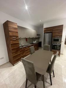 cocina con mesa y sillas en una habitación en Smart 1 Bedroom Apartment in Noah Apartments, Gzira, en Il-Gżira
