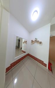 a bathroom with a mirror and a tile floor at Umi's_Homme , Conezion IOI Putrajaya in Kampong Abu Bakar