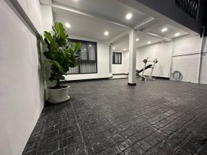 a gym room with a plant and a person on a exercise bike at Cozy home @ Chatcuchak/中文服务 in Bang O