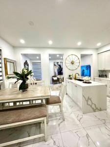 a kitchen with white cabinets and a dining table at Luxury Home in Toronto (Mississauga) in Mississauga