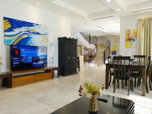 a living room with a television and a dining room at Villa Room #6 in Umm Al Sheif in Dubai
