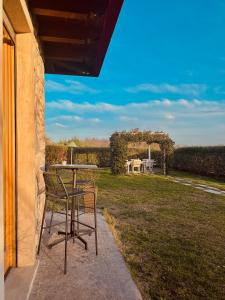 a table and chairs on a patio with a view of a field at Holiday Home Sovenigo in Puegnano del Garda