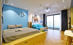 - une chambre avec un grand lit et un mur bleu dans l'établissement Harmony Vinhomes D'Capitale, à Hanoï