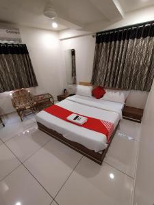 拉傑科德的住宿－Surbhi Hotel And Restaurant，一间卧室配有一张带红色毯子的大床