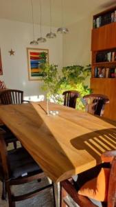 una mesa de madera en una habitación con sillas alrededor en La Maison des Roses en Drachenbronn
